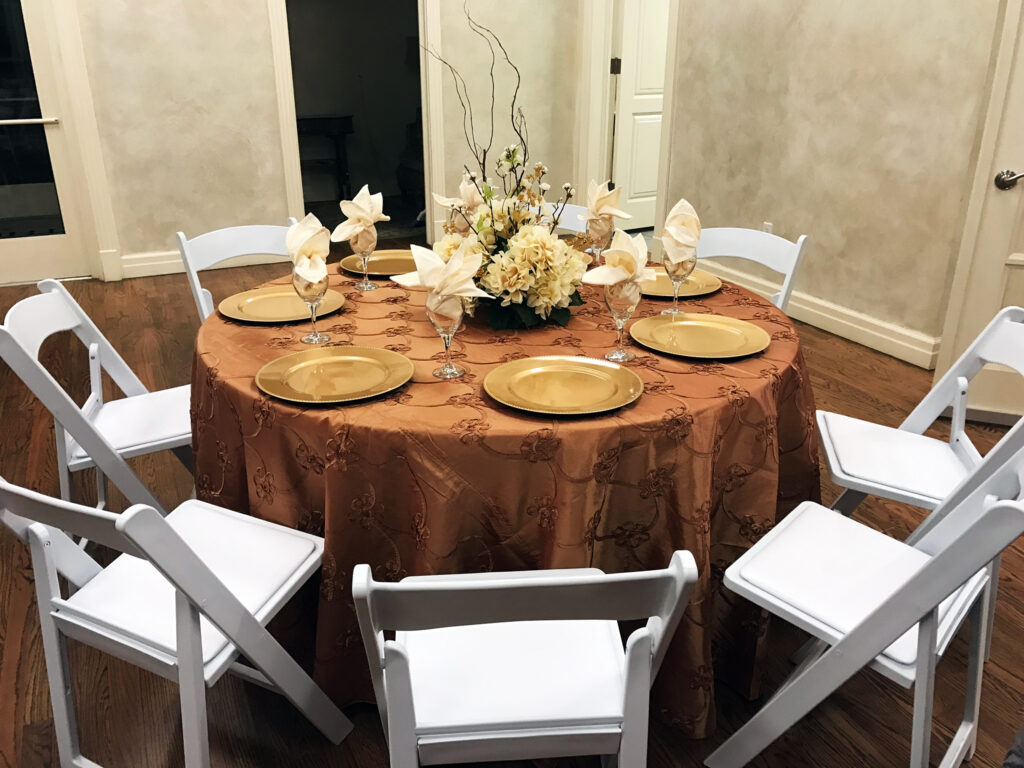Gold and orange table with wooden white chairs